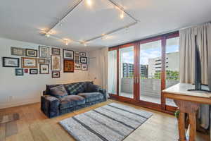 Living room featuring french doors, light hardwood / wood-style flooring, and track lighting