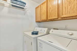 Laundry area featuring cabinets and washer and dryer