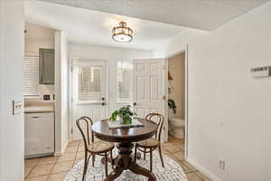 Dining room with light tile patterned floors and a textured ceiling