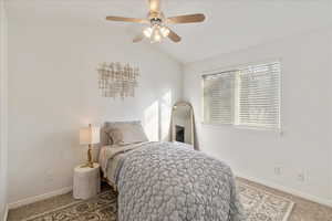 Bedroom with carpet flooring, ceiling fan, and lofted ceiling