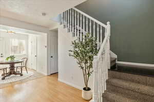 Stairway featuring hardwood / wood-style floors and a textured ceiling