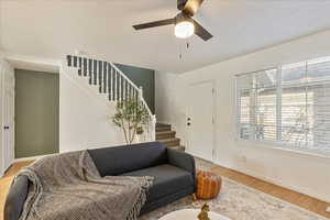 Living room with light hardwood / wood-style floors and ceiling fan