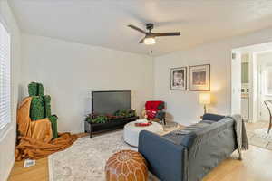 Living room featuring ceiling fan, plenty of natural light, and hardwood / wood-style flooring