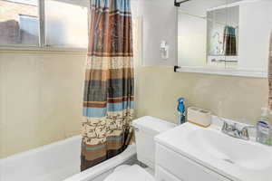 Full bathroom featuring vanity, toilet, and shower / tub combo with curtain