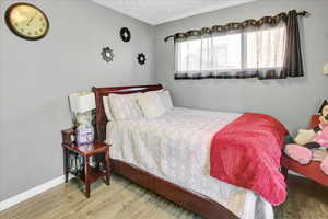 Bedroom featuring hardwood / wood-style floors and a textured ceiling