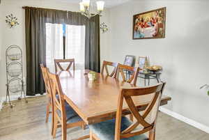 Dining room with hardwood / wood-style floors and a chandelier