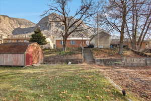 View of yard with a mountain view and a storage shed