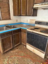 Kitchen with dark brown cabinetry, electric range, and sink