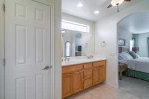 Bathroom with tile patterned floors, ceiling fan, vanity, and linen closet