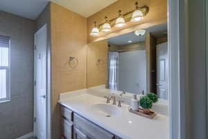 2nd bathroom featuring a shower with curtain, linen closet, and vanity