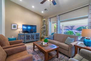 Living room featuring ceiling fan and lofted ceiling