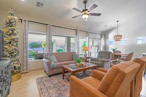 Living room with sliding glass doors, vaulted ceiling, ceiling fan, and light tile  flooring