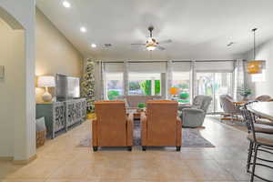 Tiled dining area with ceiling fan and lofted ceiling