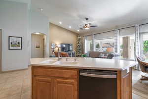 Kitchen featuring an island with sink, stainless steel dishwasher, a healthy amount of sunlight, and sink