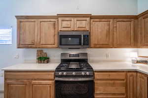 Kitchen featuring appliances with matt finish, smudge-proof, stainless steel finishes and stained alder cabinets with raised doors