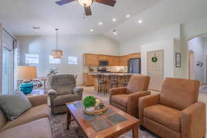 Living room with high vaulted ceiling, plenty of natural light, and ceiling fan