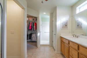 Primary bathroom with tile patterned flooring and vanity