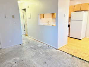 Kitchen featuring light brown cabinets, white refrigerator, light hardwood / wood-style flooring, and sink