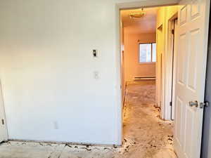 Hallway with a baseboard heating unit