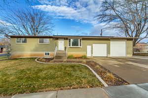 View of front of home with a garage and a front lawn