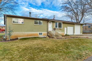 View of front of property featuring a front yard and a garage