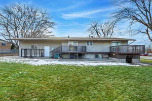 Rear view of property with a yard, cooling unit, and a wooden deck