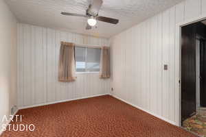 Unfurnished room featuring carpet flooring and wooden walls