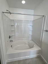 Bathroom with shower / washtub combination and tile patterned flooring