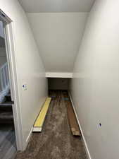 Interior space featuring carpet floors and vaulted ceiling