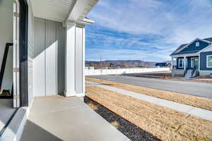 View of side of home with a mountain view, covered porch, and board and batten siding