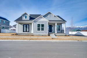 View of front of house with a porch, roof with shingles, board and batten siding, a mountain view, and crawl space