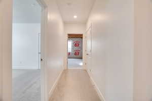 Corridor with light colored carpet and recessed lighting