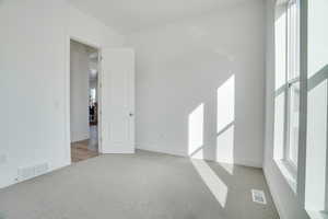 Unfurnished room featuring light colored carpet and baseboards