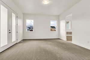 Spare room featuring carpet flooring and french doors