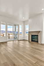 Unfurnished living room featuring a mountain view and light wood-type flooring