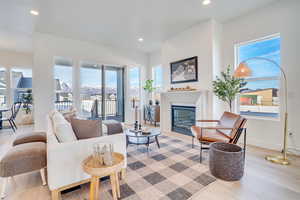 Living room with a glass covered fireplace, light wood-style flooring, and recessed lighting