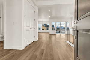 Hallway featuring light wood-type flooring and a notable chandelier