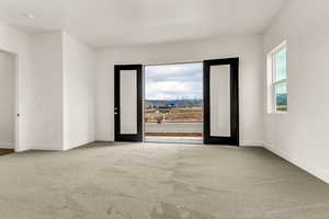 Carpeted spare room featuring french doors