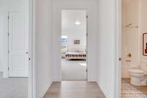 Hallway with light carpet and light wood finished floors