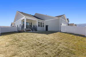 Back of house featuring a fenced backyard, a shingled roof, board and batten siding, and covered porch