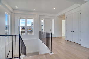 Stairway with wood finished floors and recessed lighting