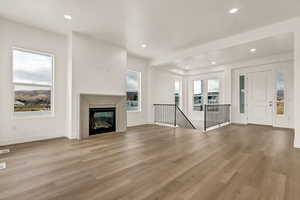 Unfurnished living room with light hardwood / wood-style floors and plenty of natural light