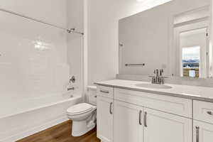 Full bathroom with hardwood / wood-style floors, vanity, toilet, and shower / bathtub combination