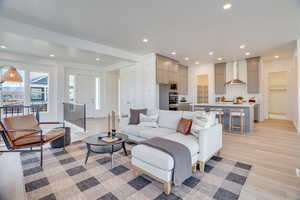 Living area with light wood-type flooring and recessed lighting