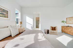 Carpeted bedroom featuring ensuite bathroom