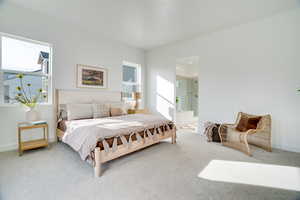 Carpeted bedroom with baseboards and ensuite bath