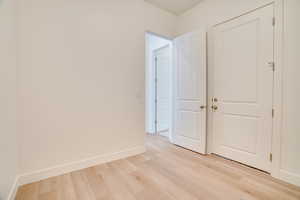 Unfurnished bedroom featuring light wood-style floors and baseboards