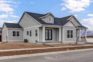 View of front of property with central air condition unit, a mountain view, and french doors