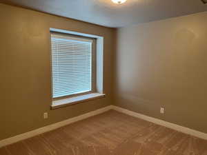 Carpeted spare room featuring a textured ceiling