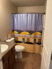 Bathroom featuring tile patterned flooring, vanity, a textured ceiling, and toilet